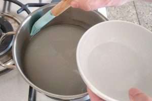 limpe as bordas da panela com um pincel e agua