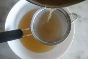 coe o caldo com um coador fino