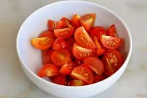 corte o tomate cereja em 4 pedaços