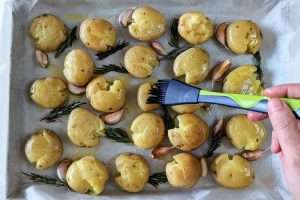 regue e pincele azeite sobre as batatas
